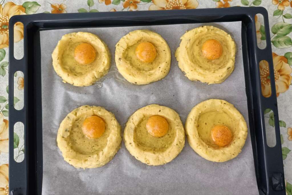 Nidi di patate con le uova crude appoggiate all'interno
